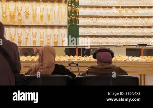 Dubau, UAE - 15th january, 2026: Customer arab tourist sit relax shopping browsing elaborate gold necklaces in display in local Dubai Gold Souq. Luxury jewelry in the world most famous gold market Stock Video Footage - Alamy