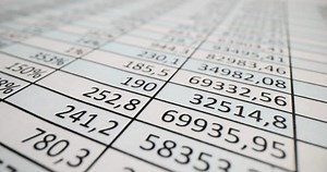 Document with columns of numbers on table in office. Accounting statistics and audit and business optimization concept