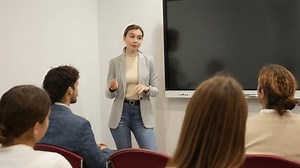 Knowledgeable female professor explaining subject to classroom full of students