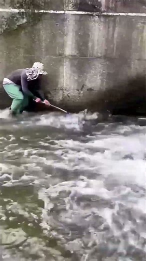 Brave showdown: man vs. raging river in fishing!