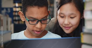 Close up of diverse school students studying and reading together in library.