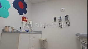 A modern medical examination room, featuring essential diagnostic equipment and a patient examination table.