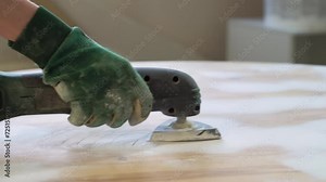 Grinding the surface of an old table with a grinding machine. Furniture renovation, DIY repair, repair by oneself and home improvement