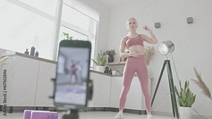 online sport coach concept. young white woman fitness coach in sportswear at home conducts individual workout in online class. Home workout training. Health practice and wellness concept