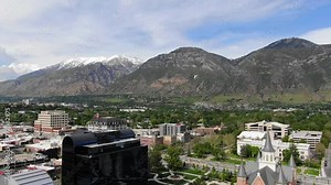 Beautiful Utah County Sunny Orem Downtown Provo Summer Wasatch Range Uinta Mountains Background Buildings Temple BYU Campus College USA 4K Street of downtown driving with clouds Stock Video