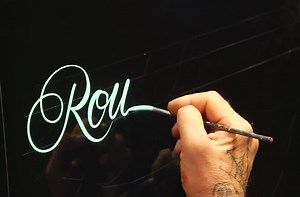 Master pinstriper demonstrates roundhand lettering.