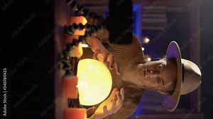 A fortune teller reading the future online using a smartphone uses an illuminated crystal ball. The concept of reading the future and predictions