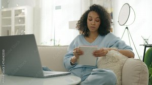 Elegant casual lady making notes in notebook. Curly female thinking through creative content plot writing. Concentrated multi ethnic girl writing down life or debt release plan. Focused woman on sofa Stock Video