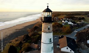 3d view of lighthouse on the beach with small housing below, sunrise