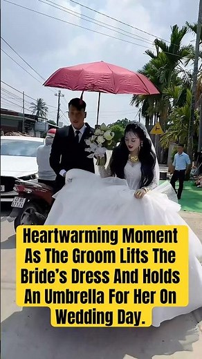 Heartwarming Moment As The Groom Lifts The Bride’s Dress And Holds An Umbrella For Her On WeddingDay