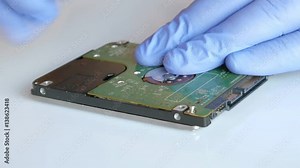 Engineer is disassembling broken hard disk drive for data recovery.