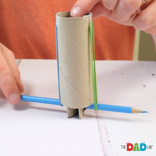 POM POM LAUNCHER! Great for sneak attacks or a game of pom-pom tag. It's really fun, and my boys were entertained for a while time with this quick and easy craft. ⭕ Materials: - 2 toilet paper rolls - pencil - scissors - 2 rubber bands - tape - pom poms ⭕ INSTRUCTIONS: (1) With one roll, fold it in half the long way, and then in half again the long way. (2) Carefully pierce the pencil near the top of your folded roll. Put the roll halfway onto the pencil. (3) On your unfolded roll, cut two paral