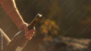 Man opens champagne bottle. Champagne explosion. Champagne popping. Sparkling Wine on sunset sunrise outdoors. Man shakes a bottle splashing champagne