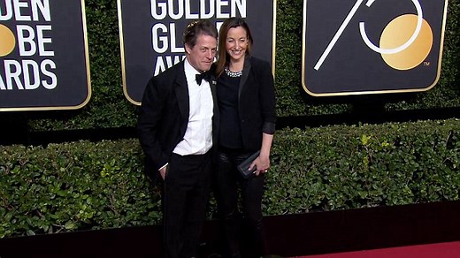 Hugh Grant & Anna Eberstein arrive in black at Golden Globes