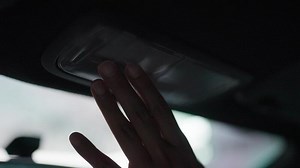 Download Hand presses Lamp of car ceiling button. Woman turns on car lights. Low angle shot. Real time car interior. for free