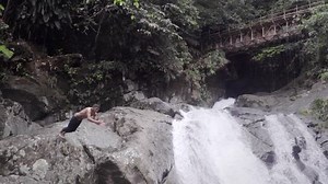 Hispanic man jumping from a high waterfall in Ecuador, Slow motion.