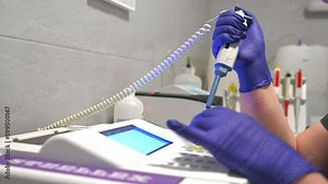 Laboratory assistant put the blood samples in the blood analyzer. Laboratory worker places a blood sample for analysis in modern lab equipment, close-up. Woman collecting blood samples from pipettes
