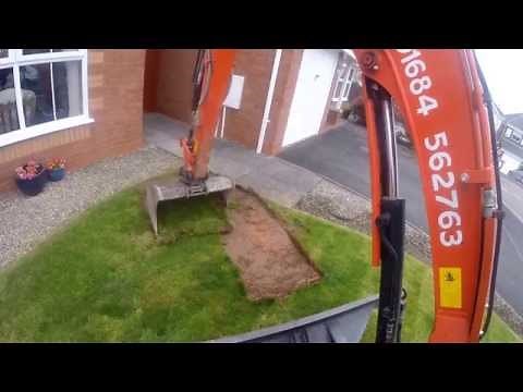 Mini Digger Removing Turf From A Lawn