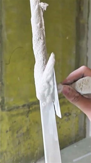 applying plaster on wall corner using a metal strip and laser level for a straight finish