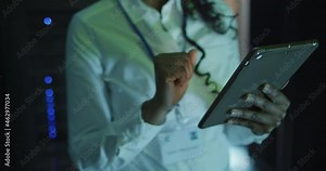 African american female computer technician using tablet working in business server room