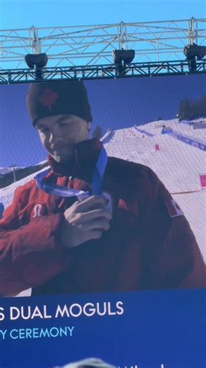 Première médaille d’or pour le Canada à Milano Cortina 🥇🇨🇦 Le drapeau canadien flotte, l’hymne national résonne, et Mikaël Kingsbury savoure ce moment unique sur le podium. ❤️ - Canada’s first gold of the Milano Cortina Games 🥇🇨🇦 The Canadian flag rises, the national anthem plays, and Mikaël Kingsbury celebrates this unforgettable moment on the podium. ❤️ | Team Canada / Équipe Canada