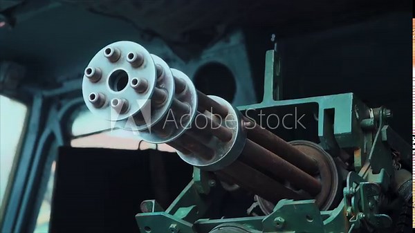 Close-up shot of a mounted Gatling-style rotary machine gun barrels inside a military vehicle or aircraft