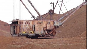 A huge dragline, a career walking excavator, rotates around its axis, doing its job. Working dragline close-up, the average plan.