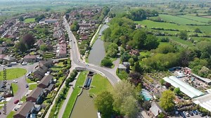Aerial drone view of canal locks with boats and road crossing over a bridge in Devizes, south England.