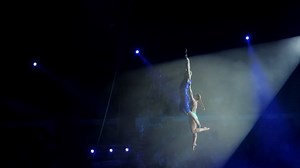 Aerial acrobat on the circus stage. A young girl and a guy perform acrobatic elements on the air ring, in the circus arena. Circus artists create shows for the audience. Flexible, athletic, aerialists