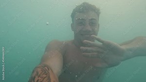 One young teenager swimming and having fun in the water with the sunset at the background.