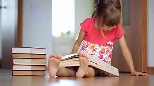 Little girl reading a big book