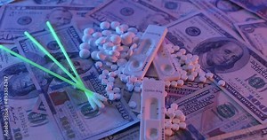 Covid rapid test on top of medicine pills and US Dollar banknotes. Cost of Rapid Antigen Home Test Kit