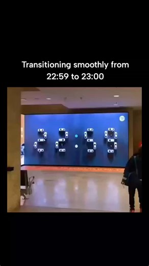 Lucky Clips on Instagram: "Posted by universal_knowledge (an account sharing interesting facts/installations). A mesmerizing 15-second clip of a unique kinetic art clock that was formerly at Ben Gurion Airport (Israel) from 2011 to 2023. It features dozens of remote-controlled toy-like cars on tracks behind a wall screen; they move precisely to form glowing digital numbers showing the time (e.g., transitioning smoothly from 22:59 to 23:00). Designed by Shlomo Sixt as a blend of engineering and a