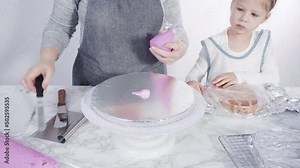 Step by step. Frosting round funfetti cake layers with pink buttercream frosting.