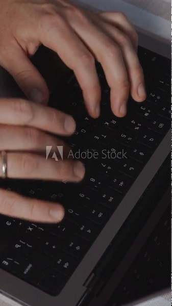 Vertical close-up video of hands typing rapidly on a laptop keyboard, showing quick movements and fast-paced workflow. Detail shot focused on productivity and deadline-driven activity. High quality 4k