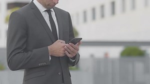 Cropped view of businessman in suit using smartphone. Partial view of manager chatting with someone. Digital device concept