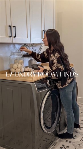 Chrissy Melin on Instagram: "Our laundry room is still a work in progress and yes, we’re planning a full redesign later this year. In the meantime, this setup has been working great. Switching to front loaders meant rethinking everything, so we added a countertop that gives us actual space to fold, sort and stay organized The collapsible laundry baskets are perfect for saving space when they’re not in use and I’ll forever swear by dryer balls… they work and they look beautiful stored in containe