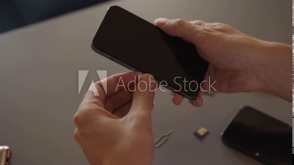 Male hands replacing nano sim card, insert into tray for new smartphone, transferring data and mobile service from old device. Concept of telecom, repair, device management. Shooting in slow motion.