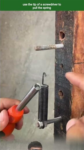 use the tip of a screwdriver to pull the spring