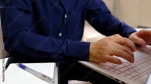 Male freelancer working on laptop at home-office. Businessman writing business letter at work or programmer writes code for a program, a reporter writes an article, student is writing his diploma.