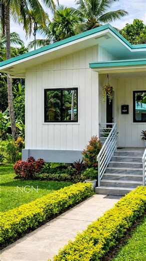 Nathaniel Guevarra Navarro on Instagram: "🇵🇭A beautifully crafted modern tropical home featuring a solid concrete structure with clean vertical panel finishes, accented by crisp white walls and a refreshing mint-green metal roof. The minimalist form is enhanced by sleek railings, shaded eaves, and black-framed windows, all set against a lush landscape of manicured lawns and towering palm trees creating a serene, elegant retreat in perfect harmony with nature. #NGN"