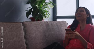 Young woman laughing at a joke she read on her phone Stock Video