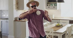 Senior man, hoop and playing for fun at home, dress up and holiday in retirement. Elderly male person, silly and goofy humor or comedy, crazy fashion and plastic toy for game and freedom or joke