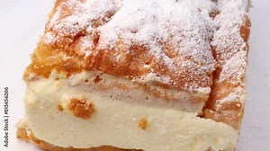 Polish traditional Carpathian cake, rotation in circle. a piece of cake, Turning. Cake made of choux pastry dough and custard cream, topped with powdered sugar.