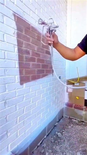 Painting red bricks pattern on a white wall with a paint sprayer very neatly and also precisely