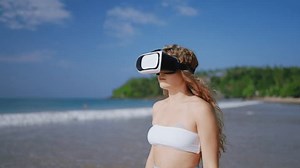 clip-3424741261-woman-vr-headset-explores-virtual-tropical-beach