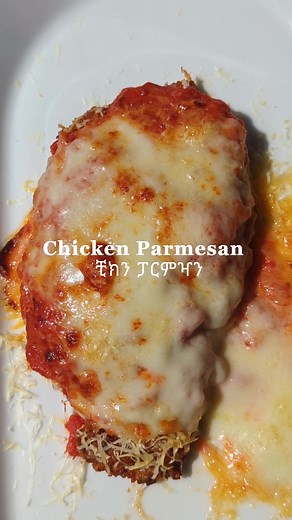 Chicken Parmesan | ቺክን ፓርምዣን Servings: 6 For The Chicken: Marinade 2 Lemons, freshly squeezed 3 Tablespoons of minced garlic or garlic sauce 3 large chicken breasts, halved horizontally to make 6 fillets 1/2 Cup all purpose flour 2 large eggs 2 cup Panko breadcrumbs 1/2 cup fresh grated parmesan cheese Salt and pepper to season 1 cup light olive oil for frying For The Sauce: 2 tablespoon olive oil 1 large onion chopped 2 teaspoons of minced garlic 14 ounces (400 g) tomato puree 3 Tablespoon of t