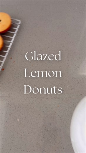 Glazed Lemon Donuts 🍋 Lemon Series Ep. 4 These cuties are light, airy and have a bright lemon flavor. This donut recipe comes together all in one bowl which makes for an easy weekend treat! Save this post or send it to a donut lover you know 💛 To make these Glazed Lemon Donuts start by preheating the oven to 350 degrees and butter a donut pan. In a large bowl massage the zest from one whole lemon with 3/4 cup of sugar. Next whisk in 1 egg until the two become pale yellow in color. Add in 1 cup