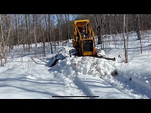 Bulldozer plowing deep hard packed snow