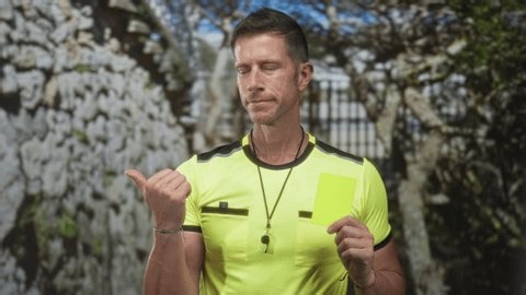 clip-4001223613-man-points-thumb-holds-yellow-card-by